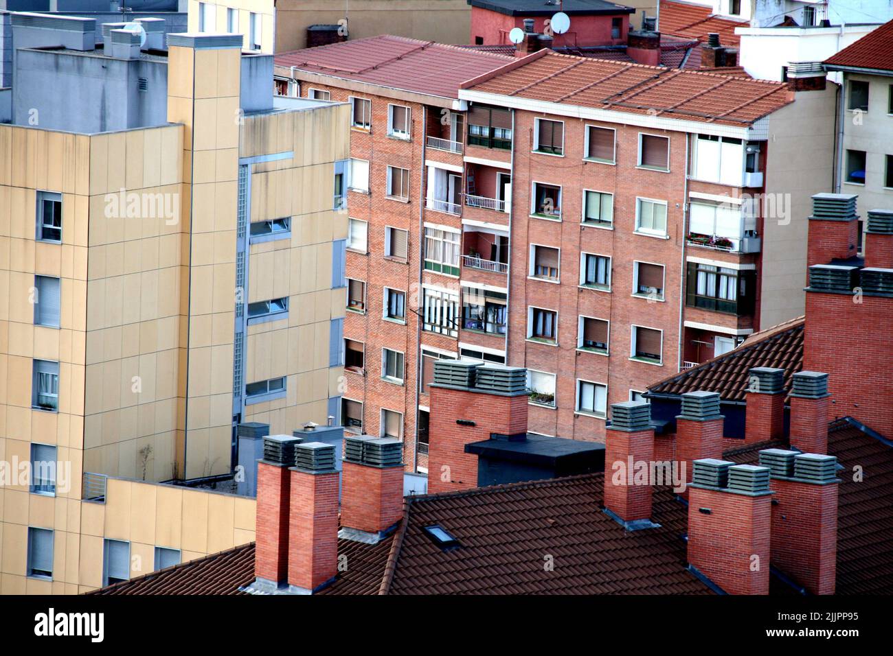 Le toit rouge et carrelé d'un bâtiment blanc avec cheminées, Bilbao, Espagne Banque D'Images
