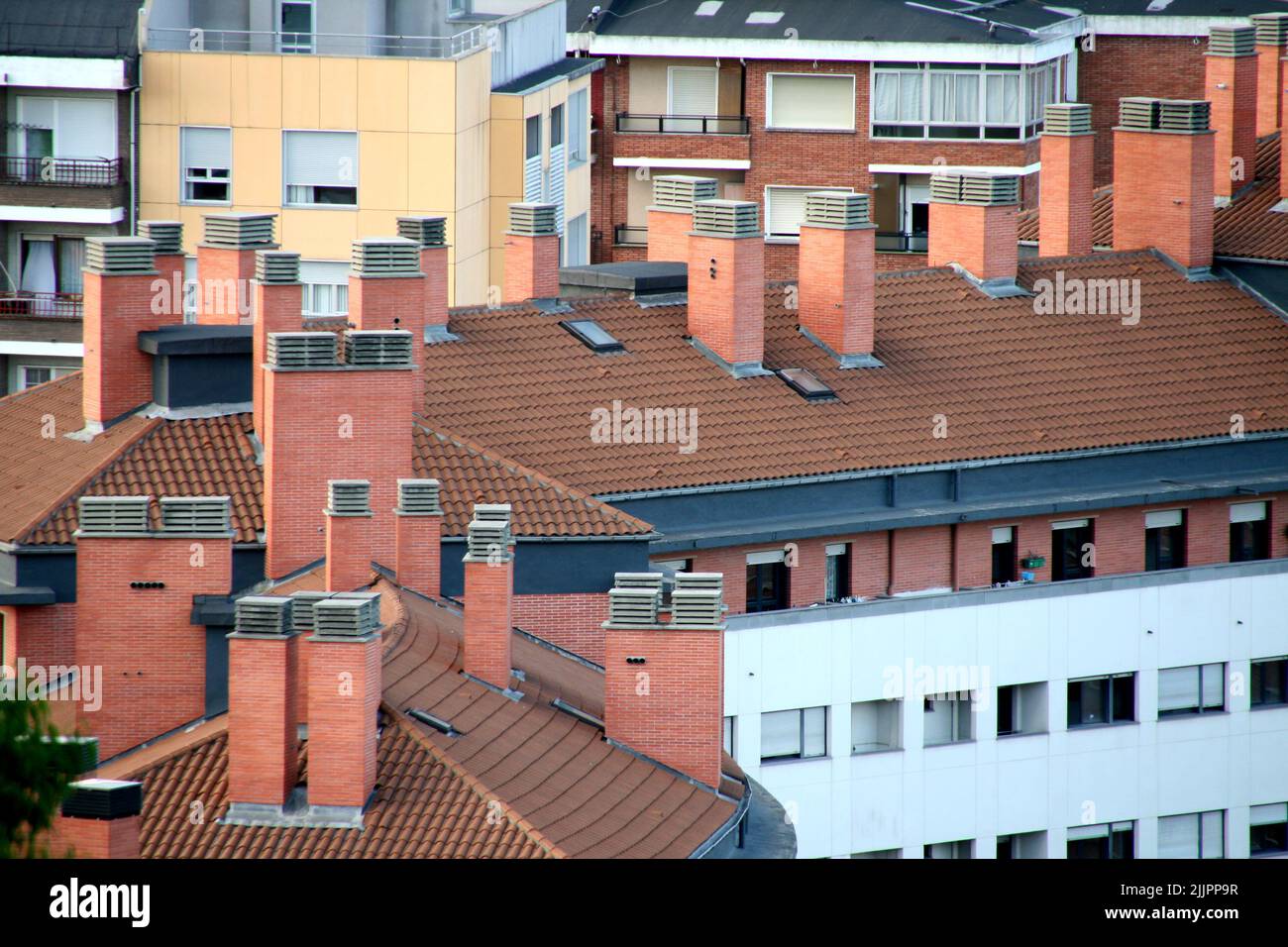 Le toit rouge et carrelé d'un bâtiment blanc avec cheminées, Bilbao, Espagne Banque D'Images