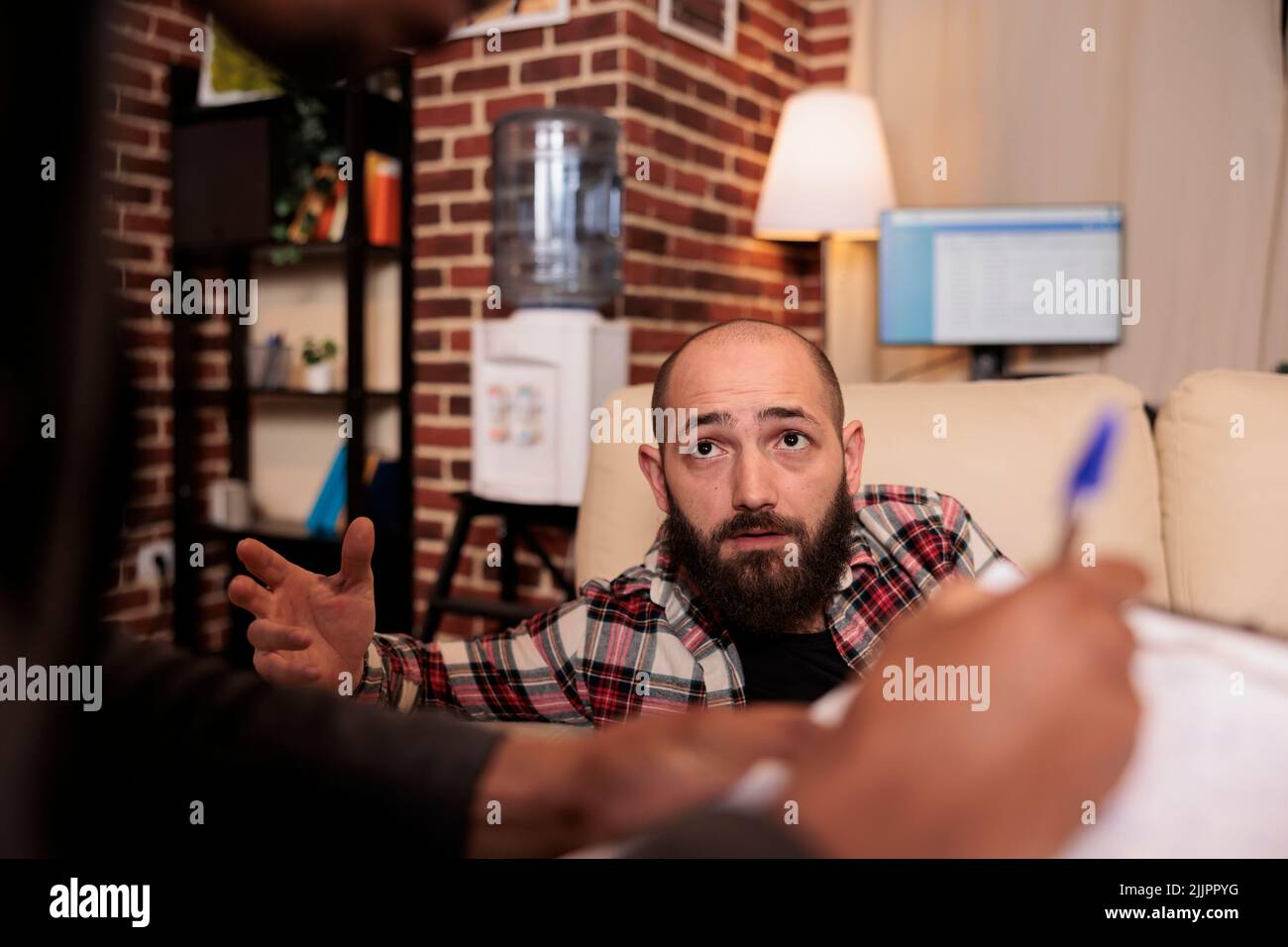 Homme caucasien parlant au spécialiste de conseil à la séance de thérapie, demandant des conseils professionnels pour résoudre des problèmes psychologiques. Patient ayant des difficultés à recevoir un soutien psychologique. Banque D'Images