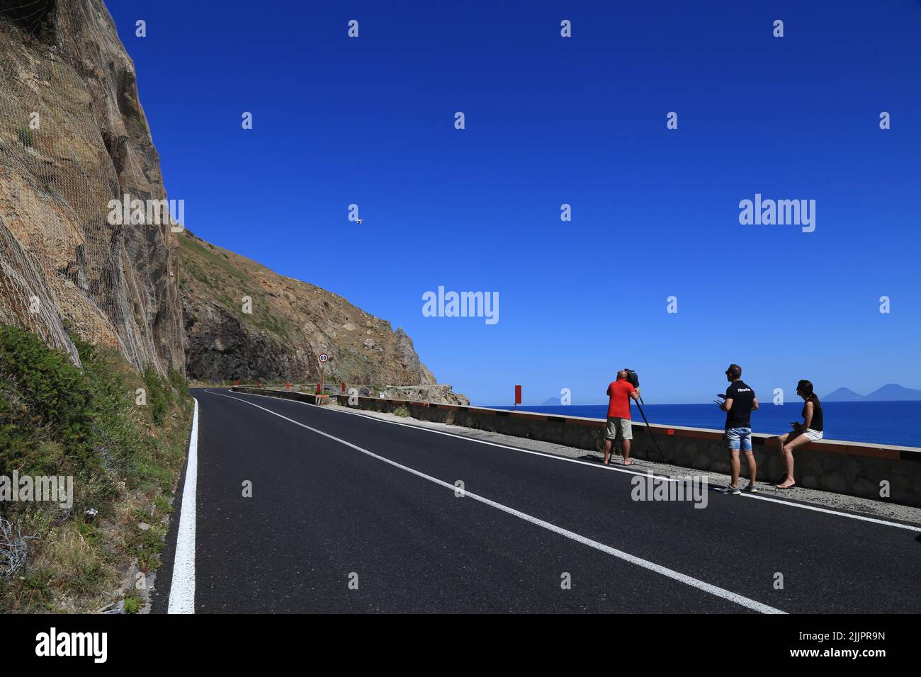 Jeunes sur la route utilisant un drone et des caméras vidéo pour photographier un paysage Banque D'Images