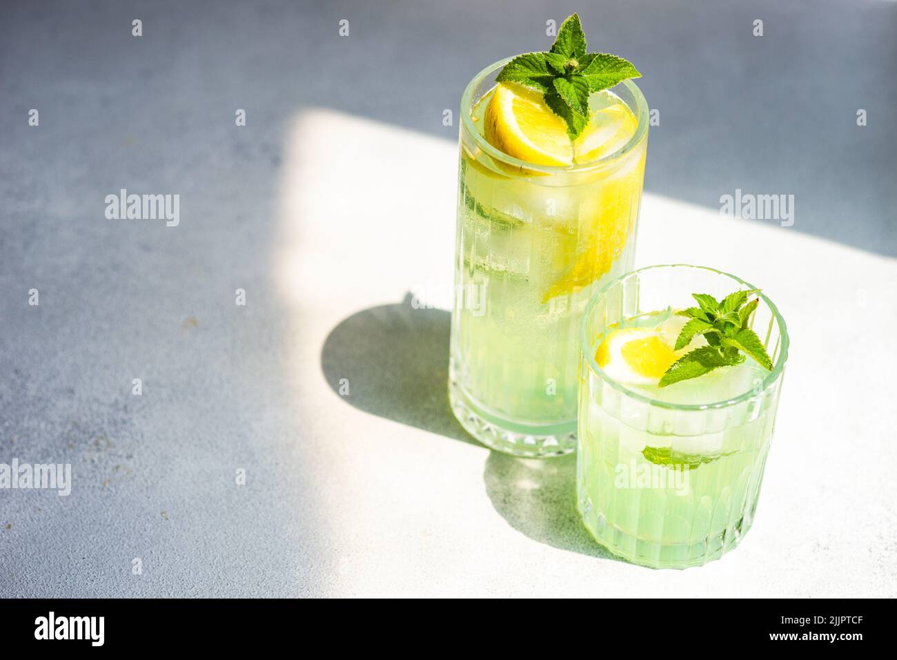 Gros plan de deux cocktails mojito sur une table avec de la menthe fraîche et du citron Banque D'Images