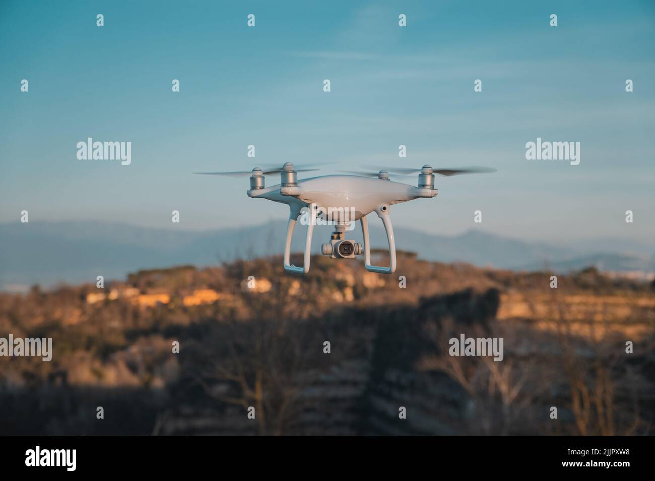 Un gros drone blanc en planant avec des constructions dans un arrière-plan flou à Rome, Italie Banque D'Images