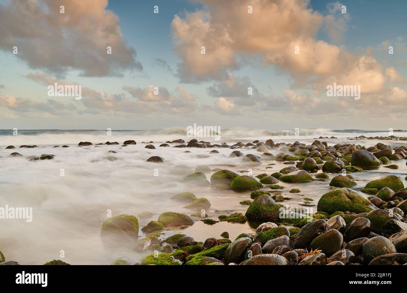 Les vagues se brisent en pierres recouvertes de mousse sur la plage d'Argyle, Saint-Vincent-et-les Grenadines Banque D'Images