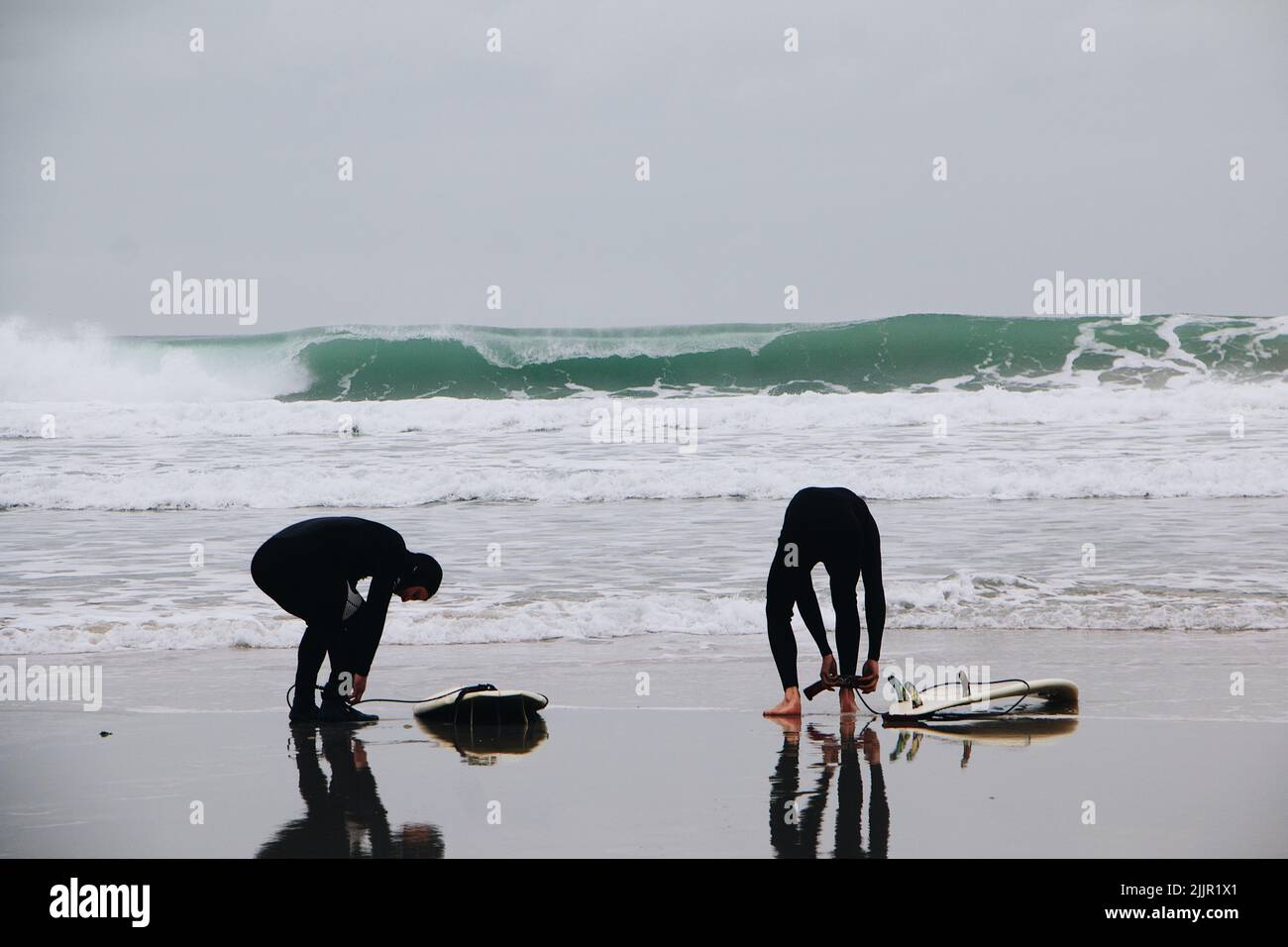 Un surfeurs sur la rive sablonneuse de l'océan. Image traitée avec VSCO avec A6 préréglages Banque D'Images