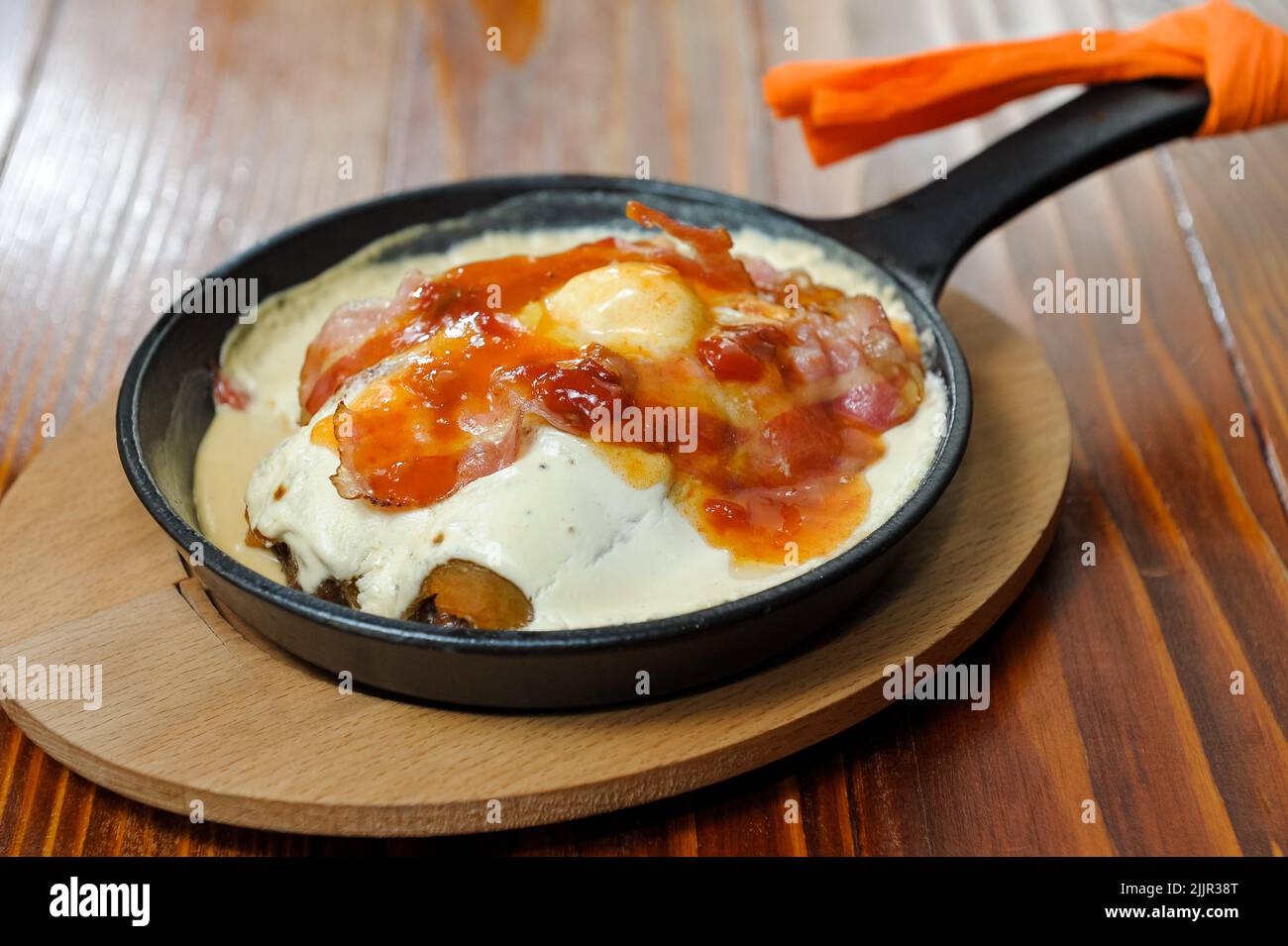 Les oeufs pochés avec des tomates et quelques épices dans la casserole Banque D'Images