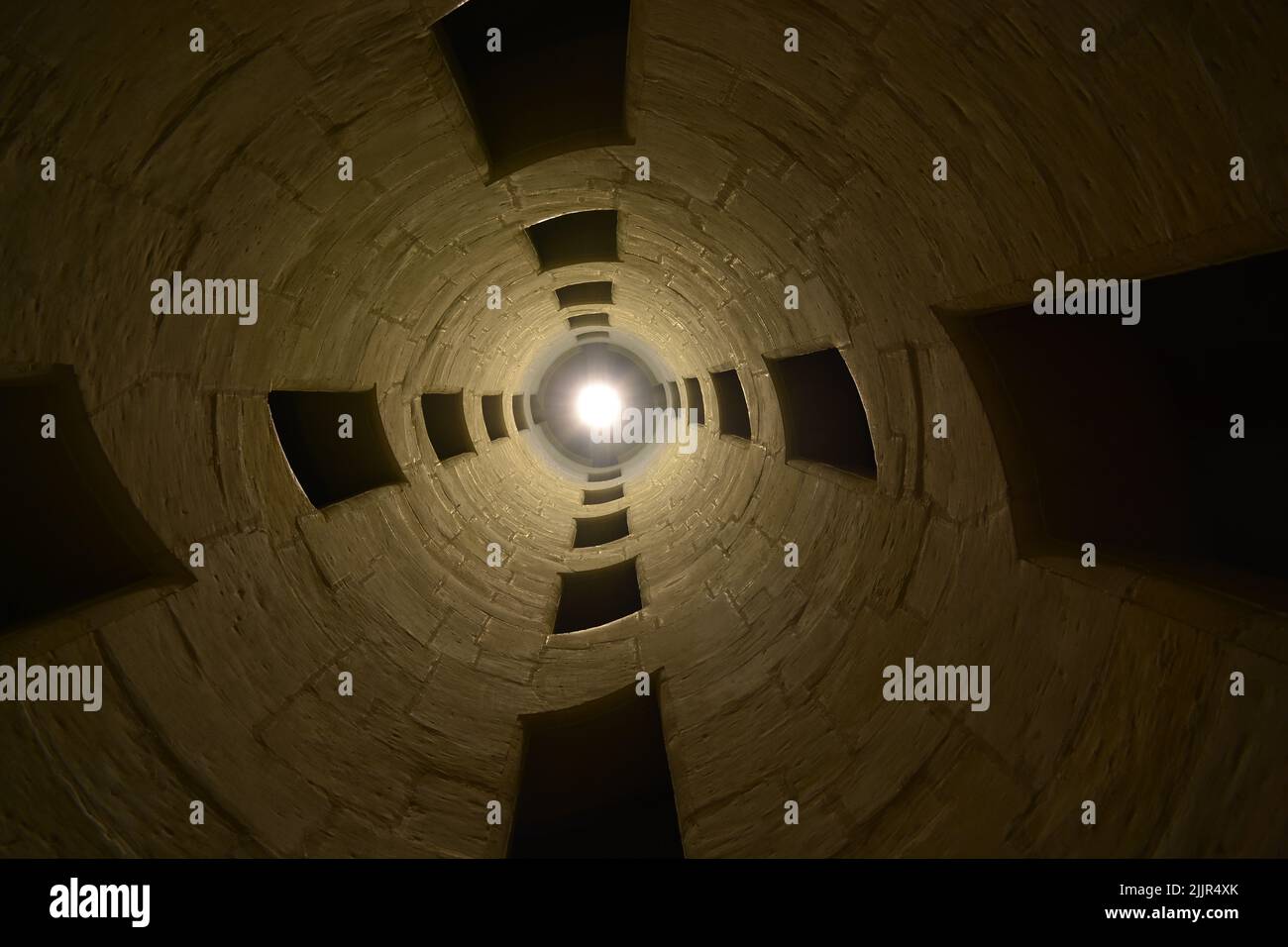 Photo en petit angle d'une lumière vive dans une grande tour en pierre Banque D'Images