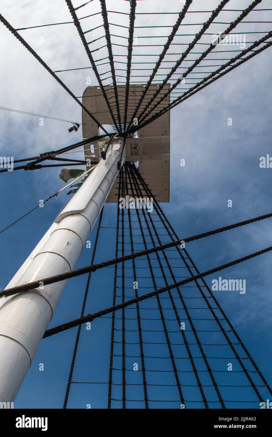 Une prise de vue verticale à angle bas du mât du navire contre un ciel bleu nuageux Banque D'Images