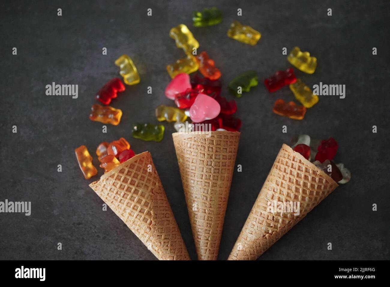 Vue de dessus de trois alvéolés avec des gelées colorées sur une surface grise Banque D'Images