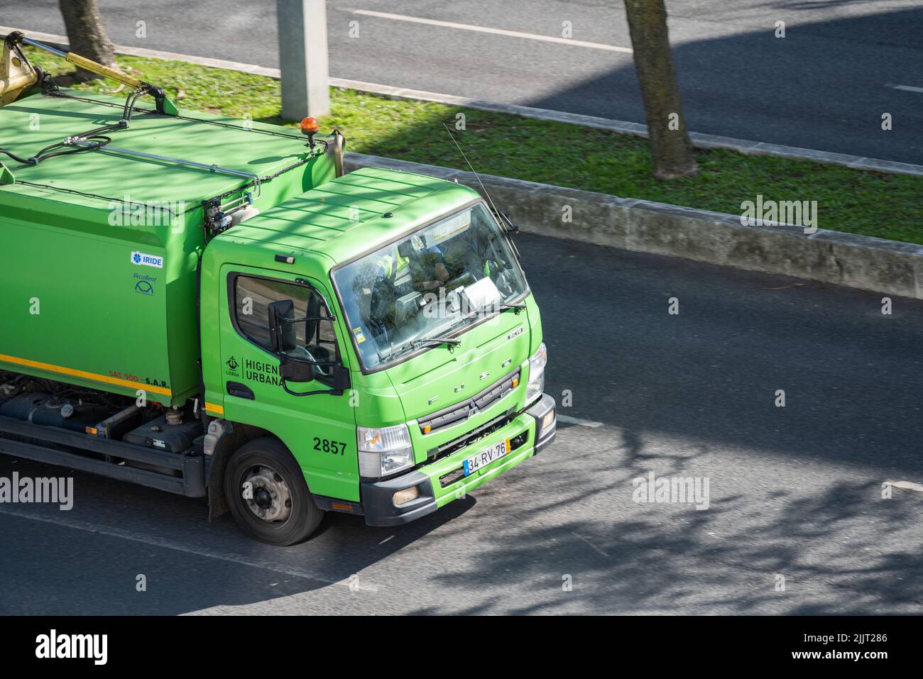 Un camion à ordures vert dans la rue de Lisbonne Banque D'Images