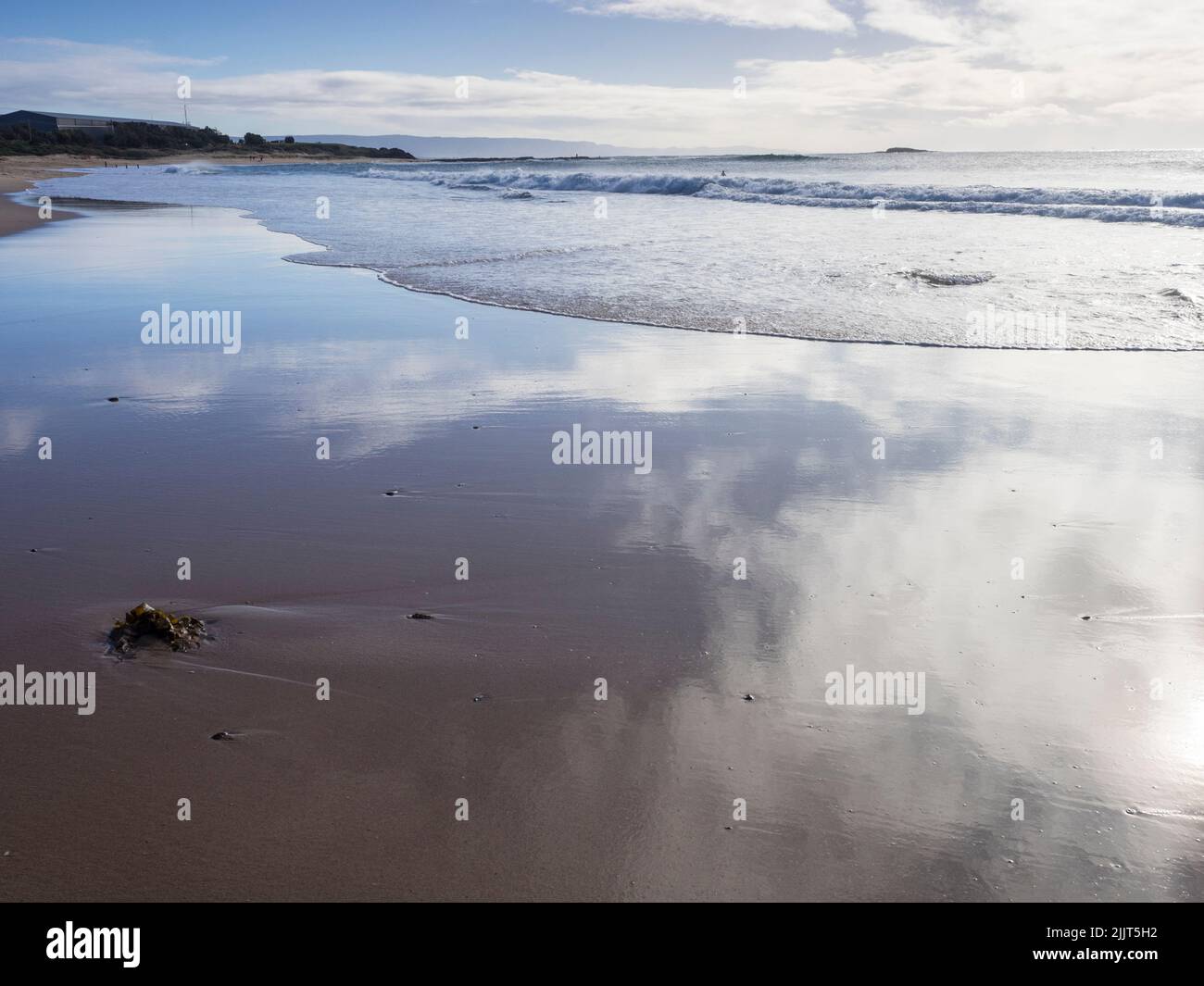 Réflexions de nuages dans le sable humide à North Beach, Port Kembla Banque D'Images