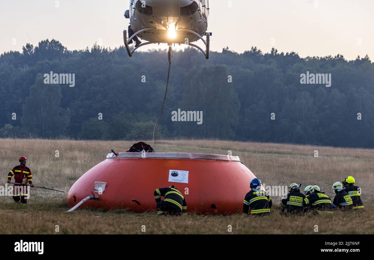 Hrensko, République tchèque. 27th juillet 2022. Hélicoptère prendre de l'eau à Bambi Bucket à partir d'un sac spécial de 54,5 mètres cubes situé près de l'incendie et rempli de pétroliers, Hrensko dans le parc national de Ceske Svycarsko (Suisse tchèque), République tchèque, 27 juillet 2022. L'incendie dans le parc national s'est propageant pour la quatrième journée consécutive. Crédit : Vojtech Hajek/CTK photo/Alay Live News Banque D'Images