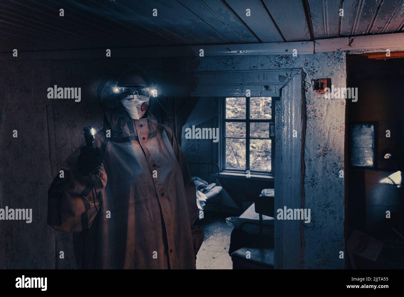 Poster de film fictif. Les gens avec des lampes de poche, des masques et des vêtements de protection inspectent la vieille maison. Personnes infectées épidémiques dans les foyers détruits. Environnement sombre et sombre, traitement du filtre. Banque D'Images