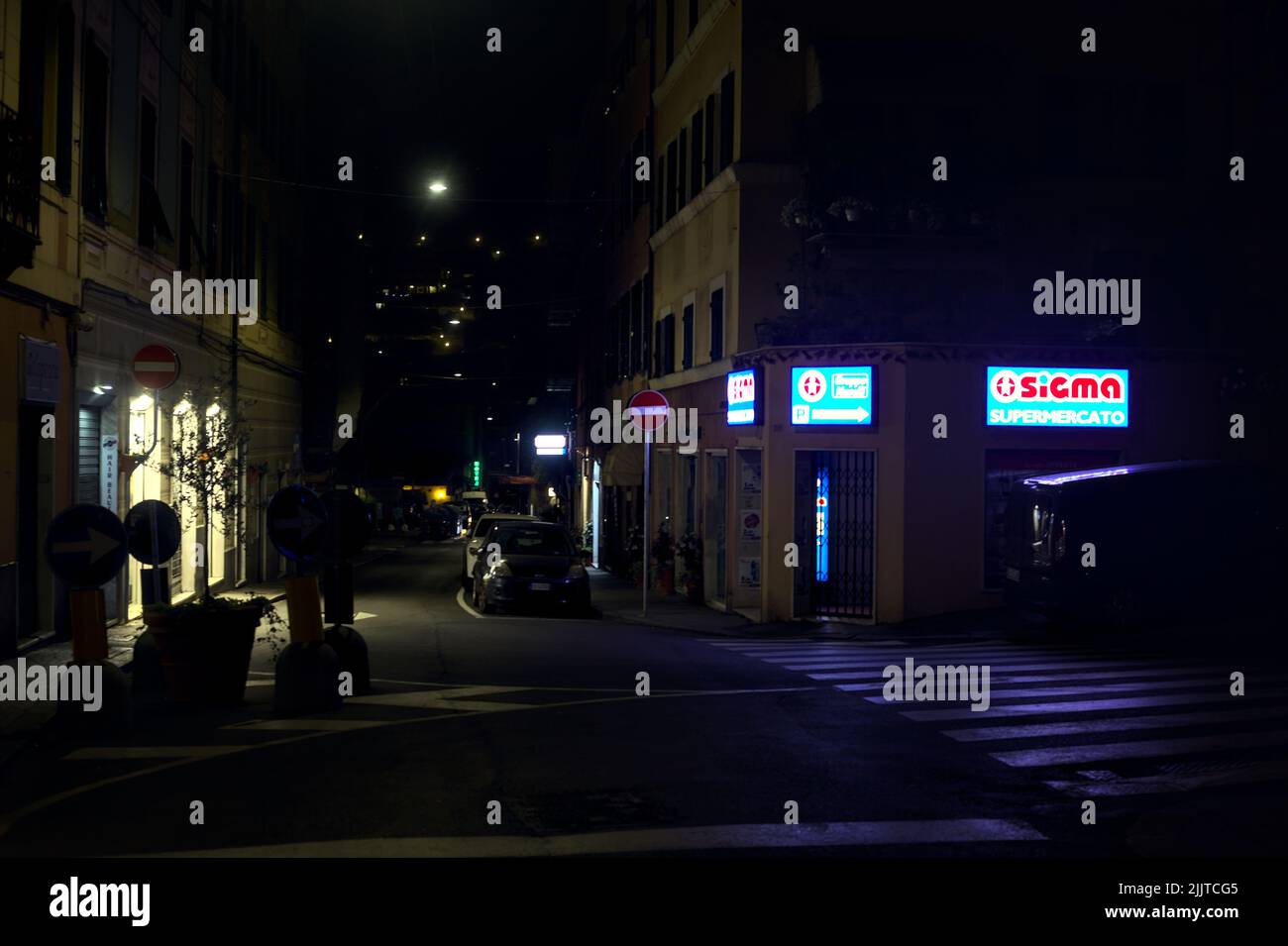 Rue la nuit avec des magasins fermés, des panneaux lumineux et des fenêtres de magasins Banque D'Images