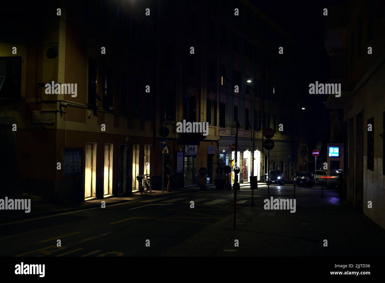 Rue la nuit avec des magasins fermés, des panneaux lumineux et des fenêtres de magasins Banque D'Images