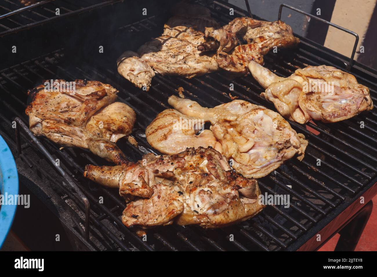 Un gros plan de poulet grillé épicé dans une grille sur barbecue au charbon de bois Banque D'Images