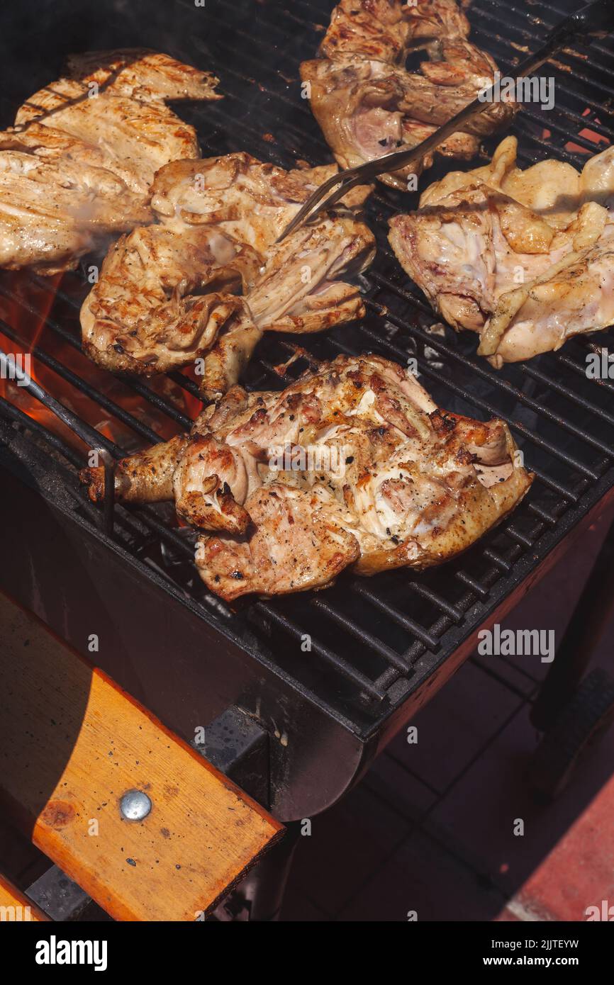 Un gros plan de poulet grillé épicé dans une grille sur barbecue au charbon de bois Banque D'Images