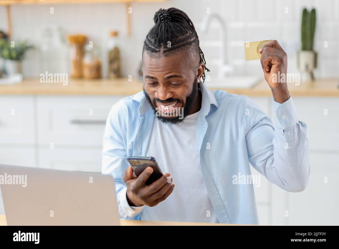 Portrait d'un homme agréablement excité magasiner en ligne à l'aide d'un téléphone mobile Banque D'Images