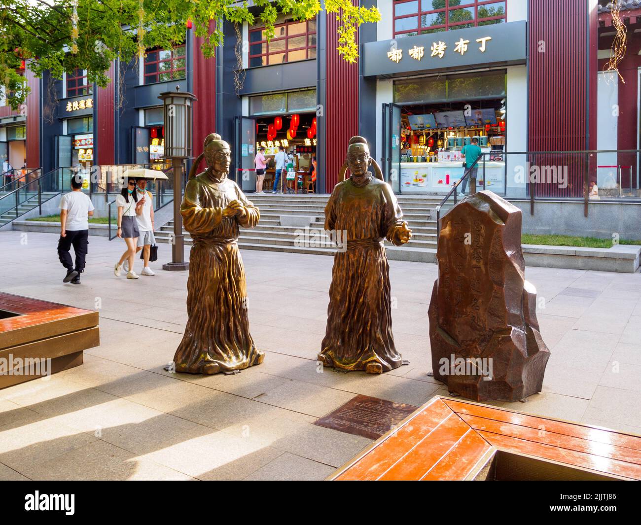 Xi'an, Chine - 5 juin 2022: Touristes marchant par des sculptures métalliques dans le centre-ville. La région est un endroit célèbre et une attraction touristique. Banque D'Images