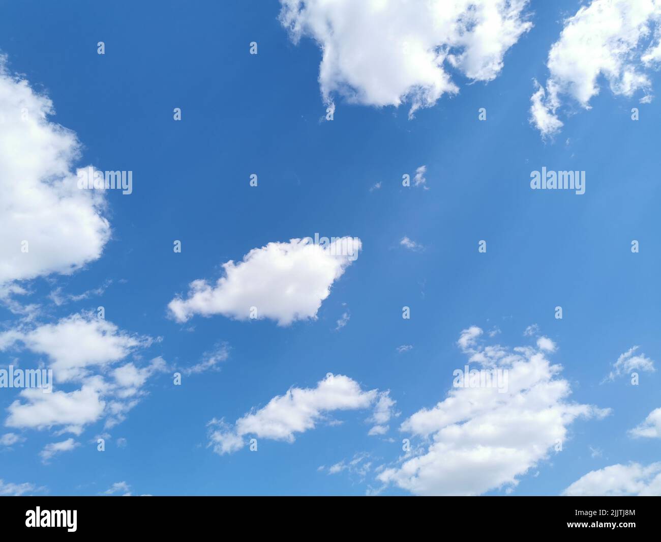 Nuages blancs semblables à du coton dans le ciel bleu Banque D'Images