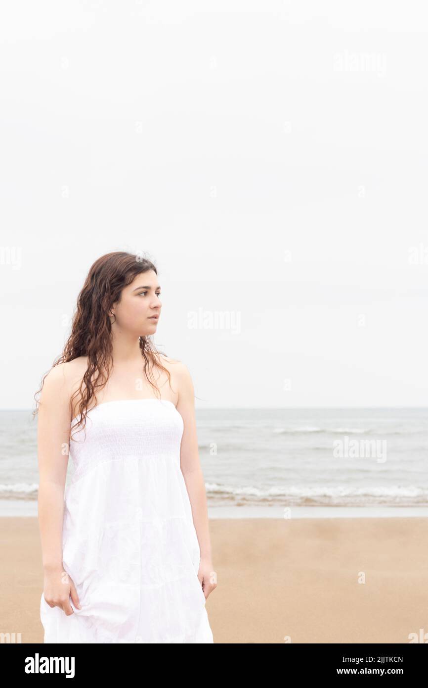 jeune femme vêtue d'une robe blanche sur la plage Banque D'Images