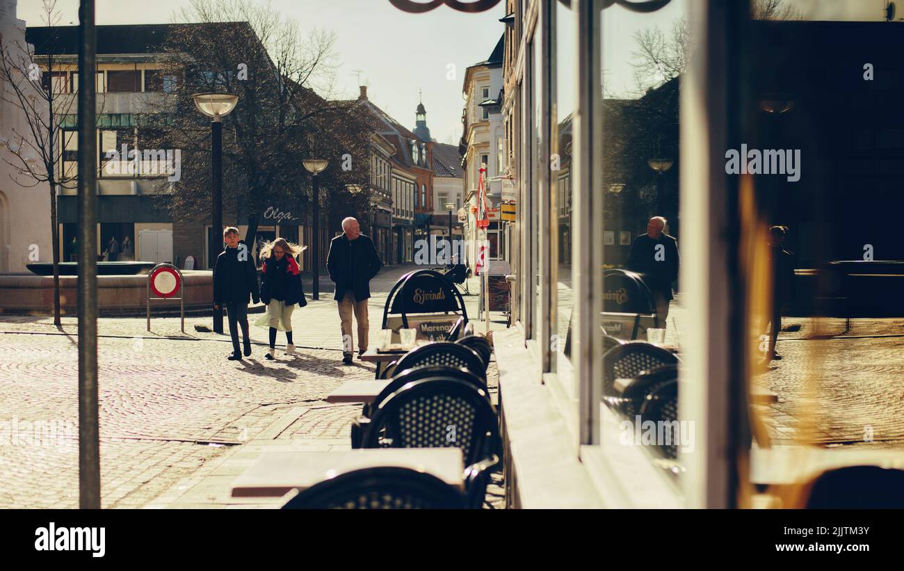 Un cliché vertical des personnes qui marchent dans la rue entre les bâtiments de Lemvig, au Danemark Banque D'Images