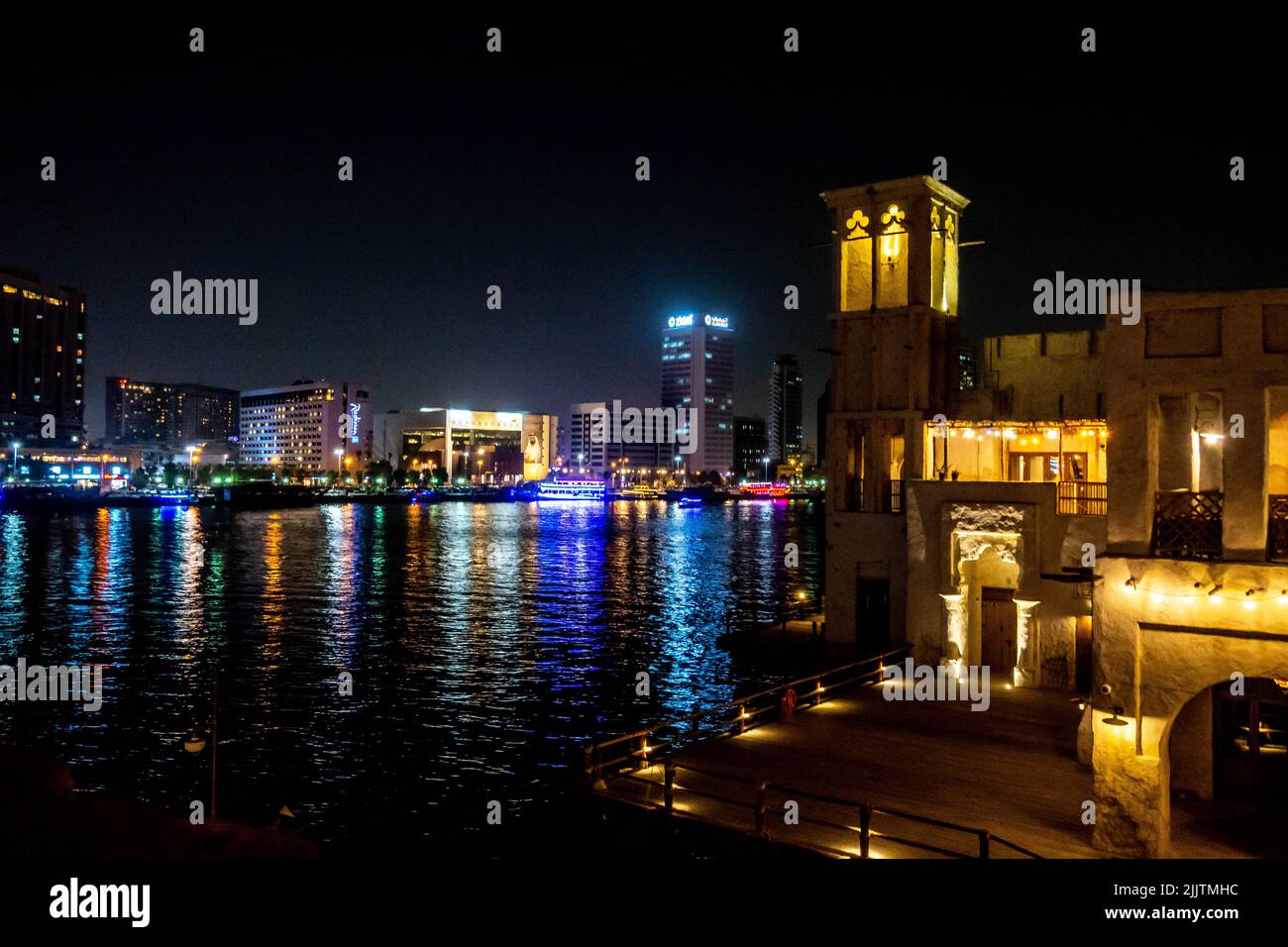 La vieille ville et la nouvelle ville entre Al seef Dubai creek pendant la nuit dans les Émirats arabes Unis Banque D'Images
