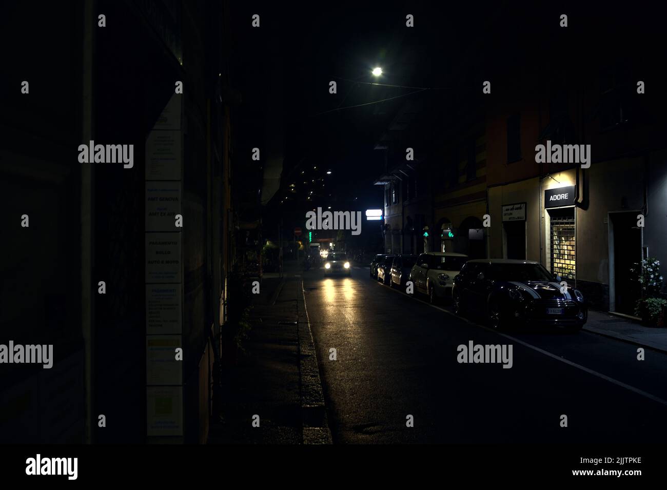 Rue la nuit avec des magasins fermés, des panneaux lumineux et des fenêtres de magasins Banque D'Images