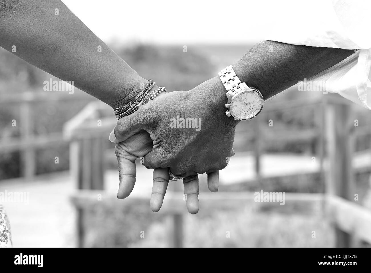 Une photo en niveaux de gris de deux mains se tenant les unes les autres sur Burns Beach à Perth, en Australie Banque D'Images