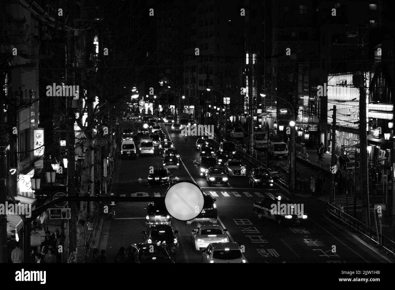 Vue nocturne en niveaux de gris sur une rue de Tokyo Banque D'Images