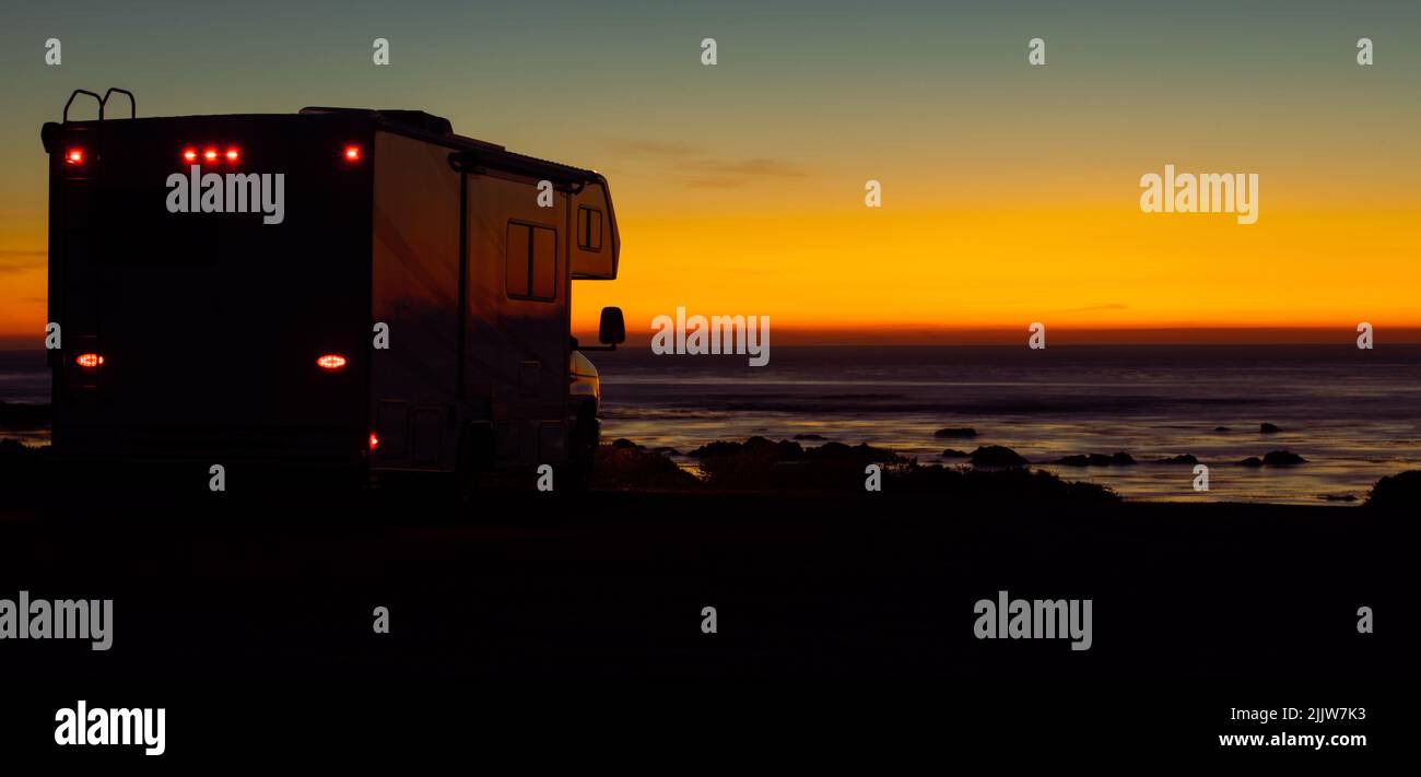 Fourgonnette de classe C et coucher de soleil sur la plage panoramique Ocean Beach. Voyage en voiture. Véhicules récréatifs thème panoramique Banque D'Images