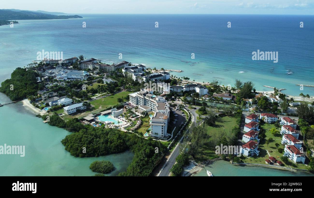 Une antenne d'hôtels sur une plage couverte de verdure contre une mer turquoise à Montego Bay, Jamaïque Banque D'Images