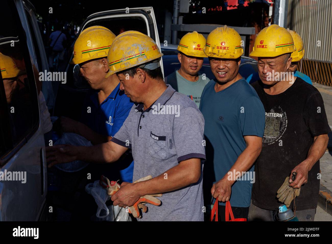 Les travailleurs quittent le chantier de construction du nouveau stade des travailleurs à Pékin, en Chine, au 28 juillet 2022. REUTERS/Thomas Peter Banque D'Images