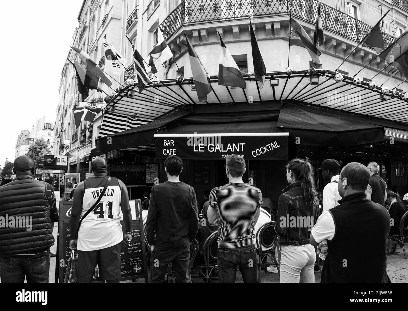 PARIS, FRANCE - 24 JUIN 2018 : les gens regardent 2018 matchs de la coupe du monde de football (les équipes du Sénégal et du Japon jouent) sur la terrasse du café-bar parisien. Noir blanc Banque D'Images