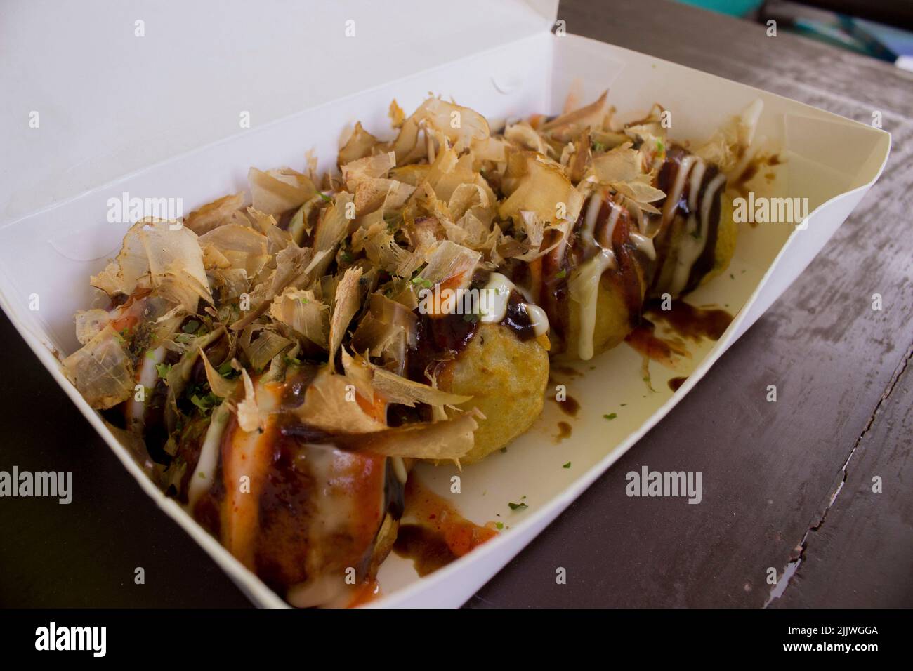Le takoyaki est de la nourriture japonaise, sous forme de petites boules faites de farine de pâte remplie de morceaux de poulpe. la nourriture japonaise, isolée dans le fond de bois Banque D'Images
