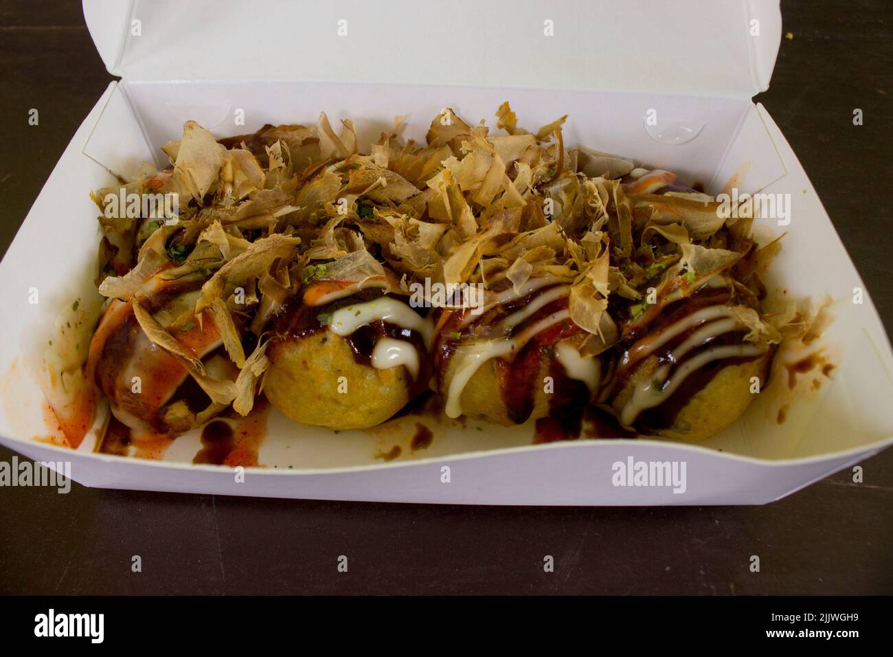 Le takoyaki est de la nourriture japonaise, sous forme de petites boules faites de farine de pâte remplie de morceaux de poulpe. la nourriture japonaise, isolée dans le fond de bois Banque D'Images