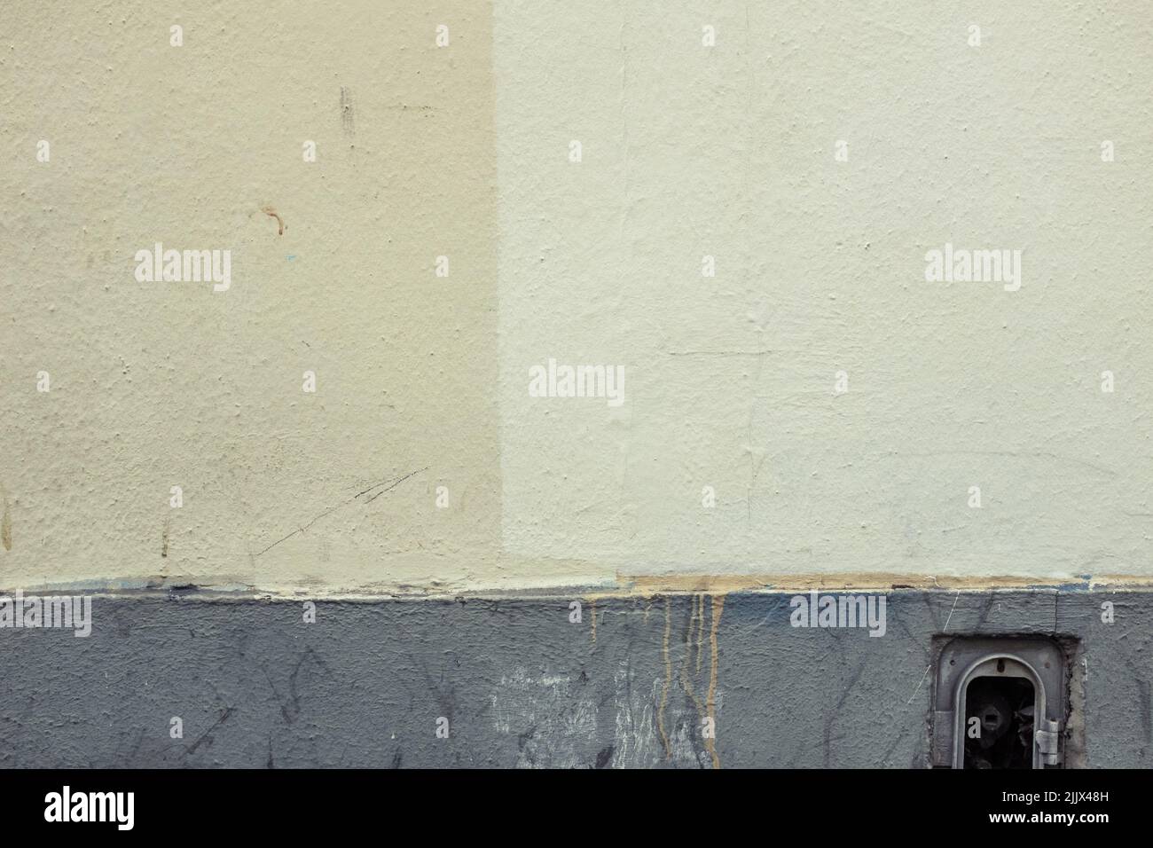 Mur en plâtre d'un ancien bâtiment peint dans différentes teintes de couleur crème sur la rue de la ville en journée Banque D'Images