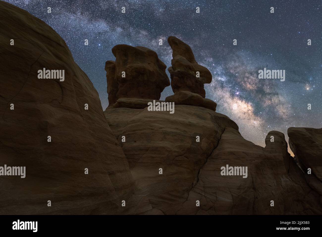 De grandes formations rocheuses lisses au Devils Garden, dans le Grand Staircase Escalante National Monument, sous un ciel laiteux et étoilé la nuit Banque D'Images