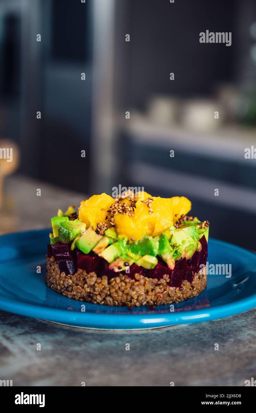Accompagnement doux d'une délicieuse couche de salade faite de quinoa et de betteraves avec avocat et mangue et servi sur plaque dans la cuisine à la maison Banque D'Images