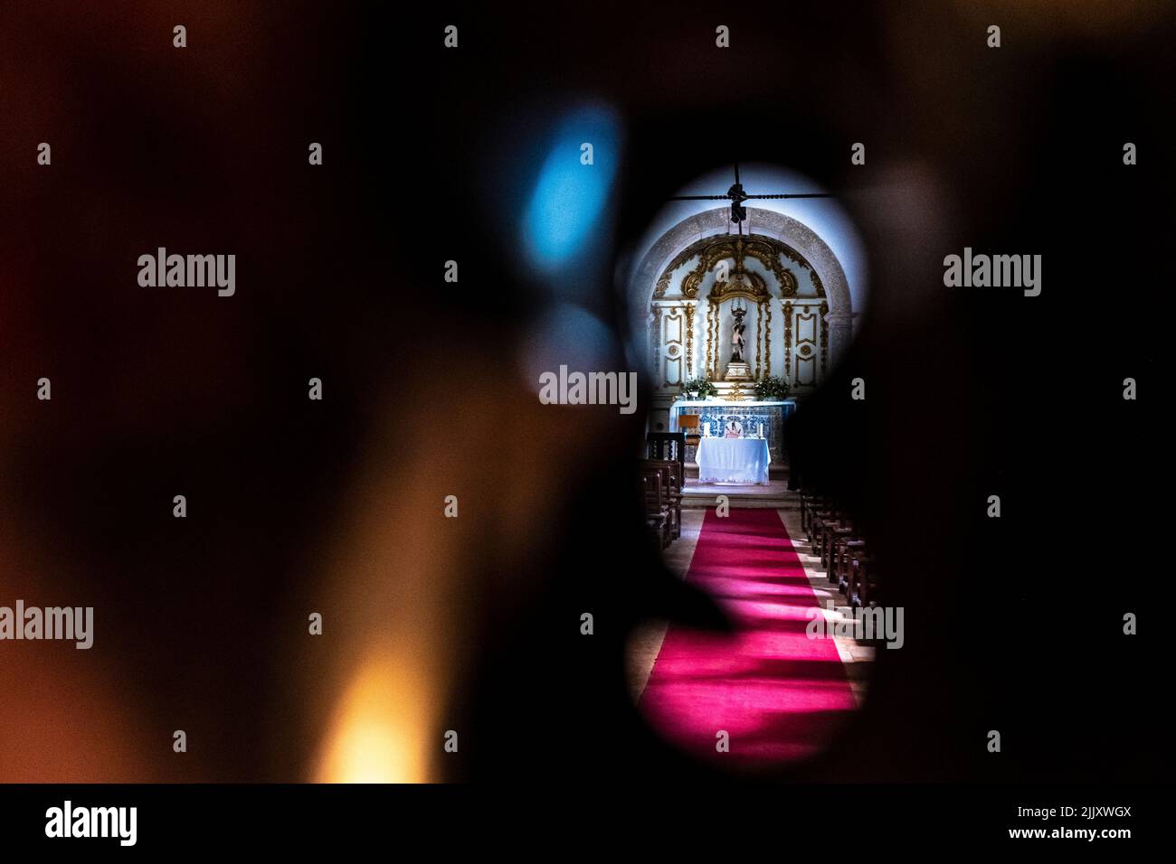 Vue à travers un trou de serrure sur l'autel d'une chapelle catholique à Cascais, Portugal Banque D'Images