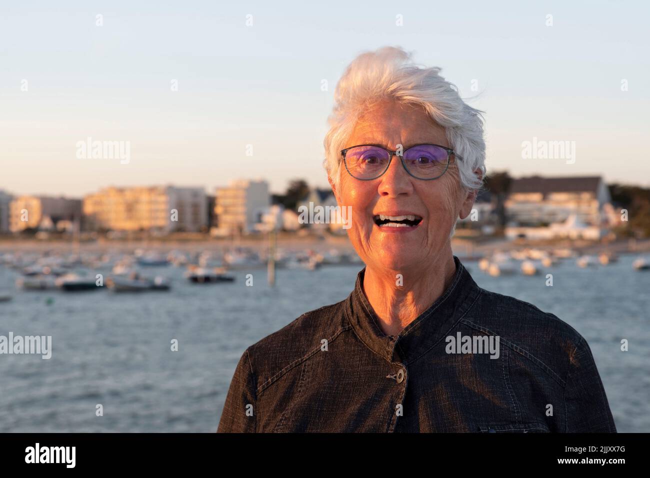 Portrait d'une femme âgée au bord de la mer en Bretagne sous un coucher de soleil Banque D'Images