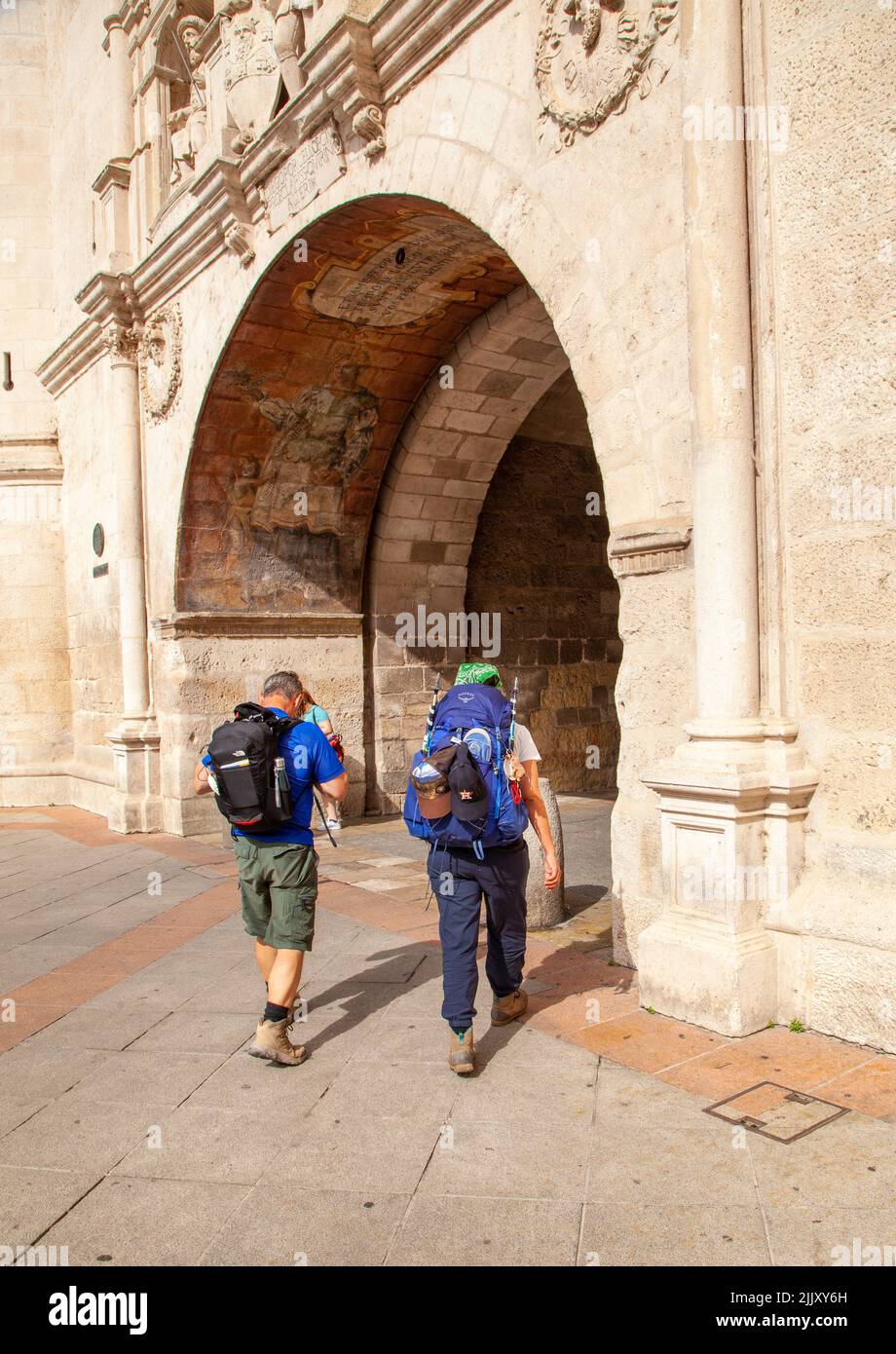Pèlerins marchant sur le Camino de Santiago, le chemin de Saint-Jacques entrant dans la porte de la ville de Santa Maria, dans la ville espagnole de Burgos Espagne Banque D'Images
