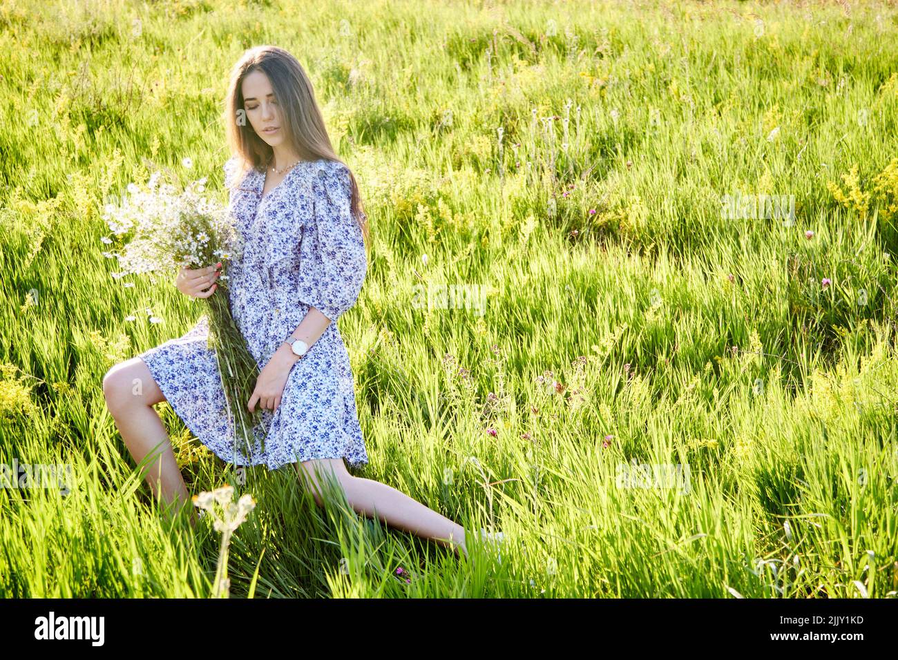 jeune belle fille avec un bouquet de fleurs dans la nature Banque D'Images