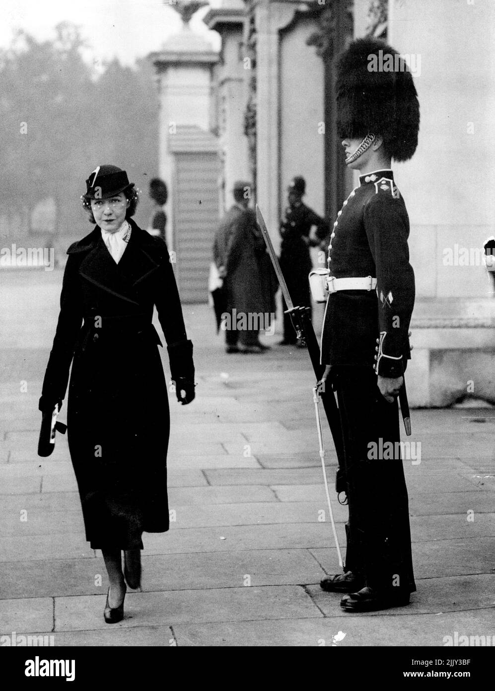 GISH portant un militaire intelligent ***** Et chapeau Shako et ***** passage d'une des entrées ***** Palais de Buckingham. Madame Dorothy GISH, le film et ***** Star, est maintenant à Londres sur une courte visite, et est 'Ding London'. 07 novembre 1932. (Photo de l'Associated Press of Great Britain Ltd.). Banque D'Images