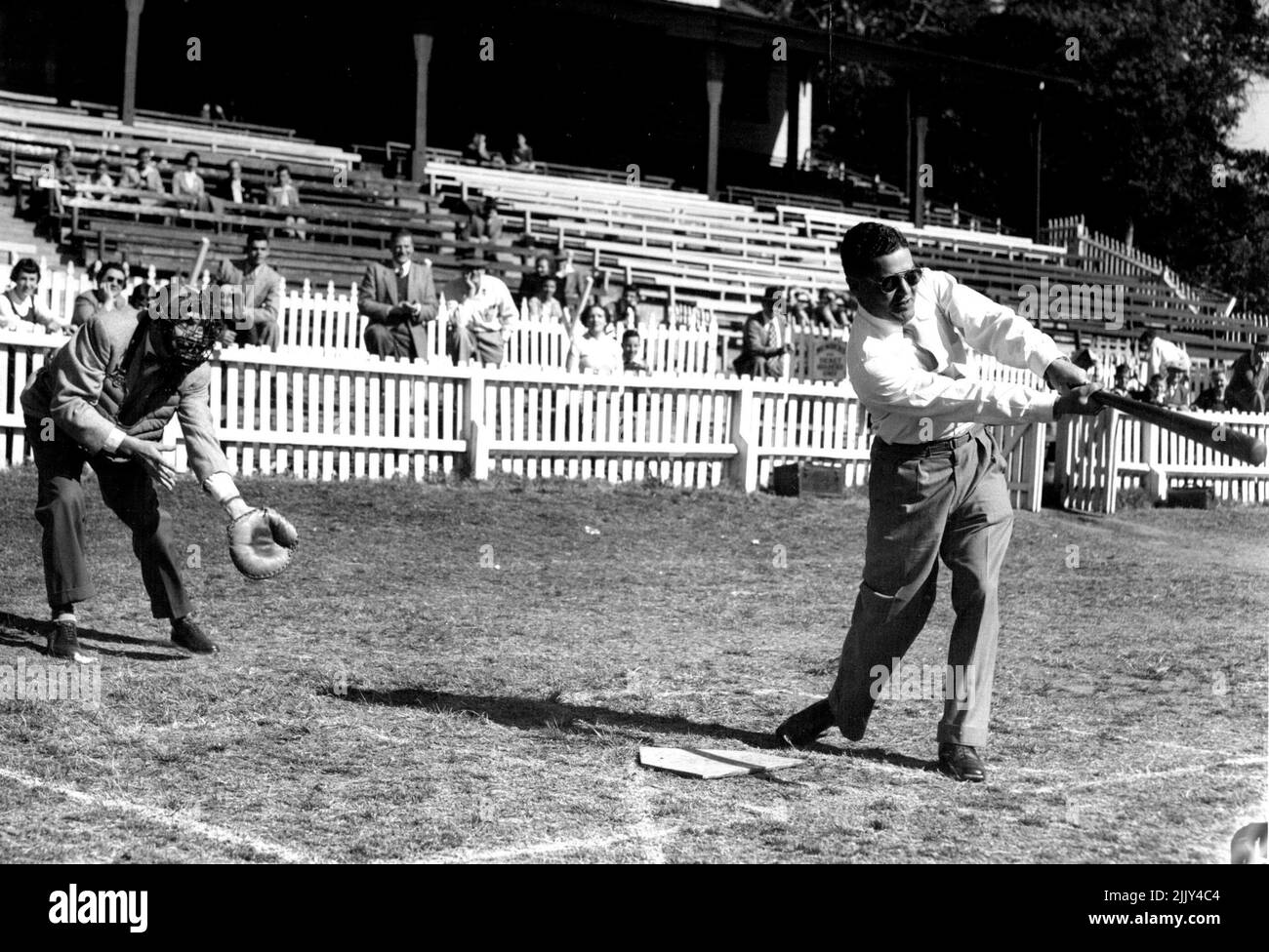 Manly Juvenile Baseball final - le maire de Manly Ald. M. Paine frappe à la balle qu'il a reçue de ****** catcher est M. R. Hauslaib, président du American National Club. Le consul général américain, M. B. More, a fait le premier discours devant le maire de Manly, pour ouvrir la finale de la Ligue de baseball pour mineurs de Manly à Manly. Les deux équipes, Collaroy Cubs et Balgowlah Tigers, jouèrent pour une batte présentée par les Detroit Tigers. 27 août 1955. (Photo de James G. Hopwood/Fairfax Media) Banque D'Images