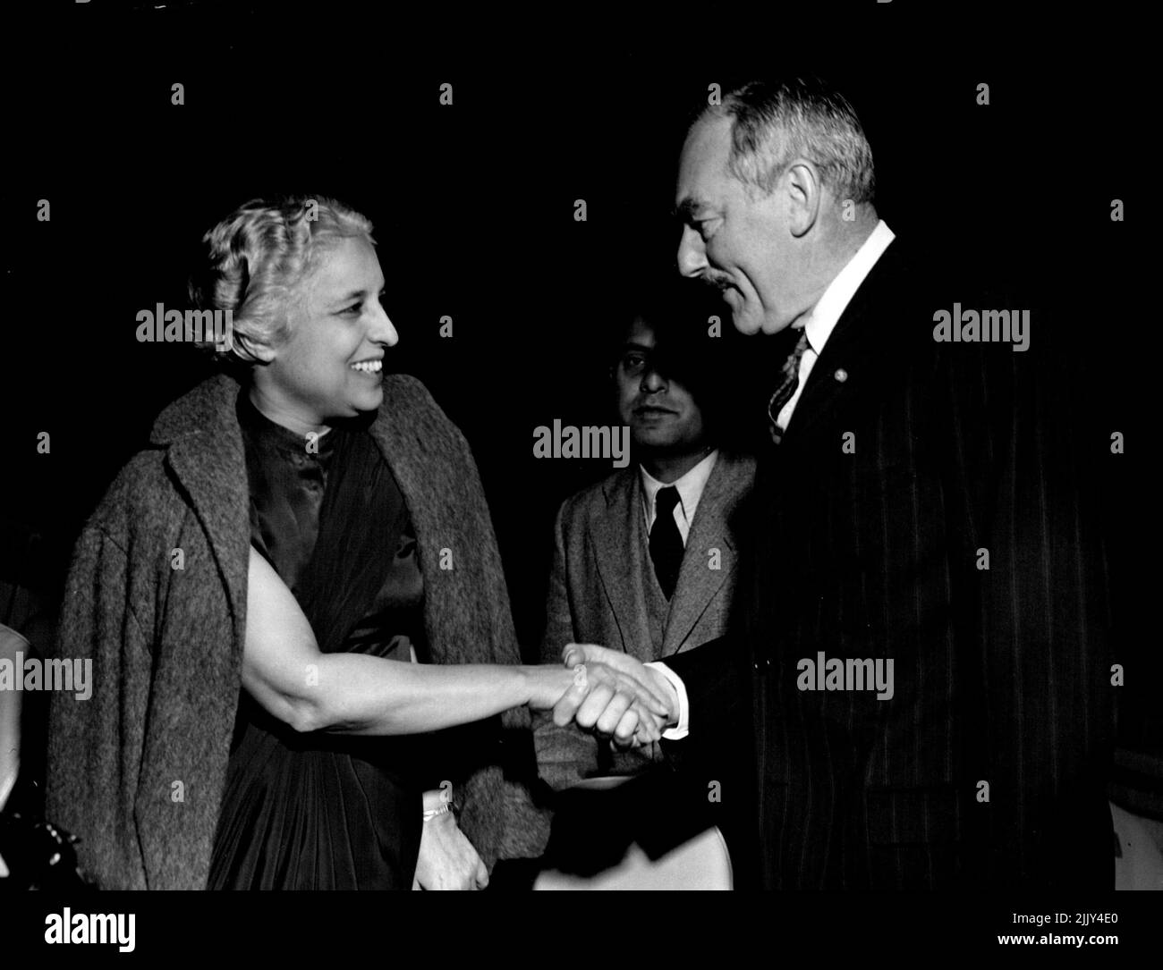 Les femmes à l'Assemblée générale des Nations Unies de nombreux pays ont des femmes parmi leurs délégués de haut rang à la session de 7th de l'Assemblée générale des Nations Unies. Cette photo montre l'une d'entre elles, Mme Vijaya Lakshmi Pandit, Présidente de la délégation de l'Inde, qui se met entre la main avec M. Dean Acheson, Secrétaire d'État des États-Unis. Mme Pandit est ancienne ambassadrice à Moscou et à Washington. 1 octobre 1952. Banque D'Images