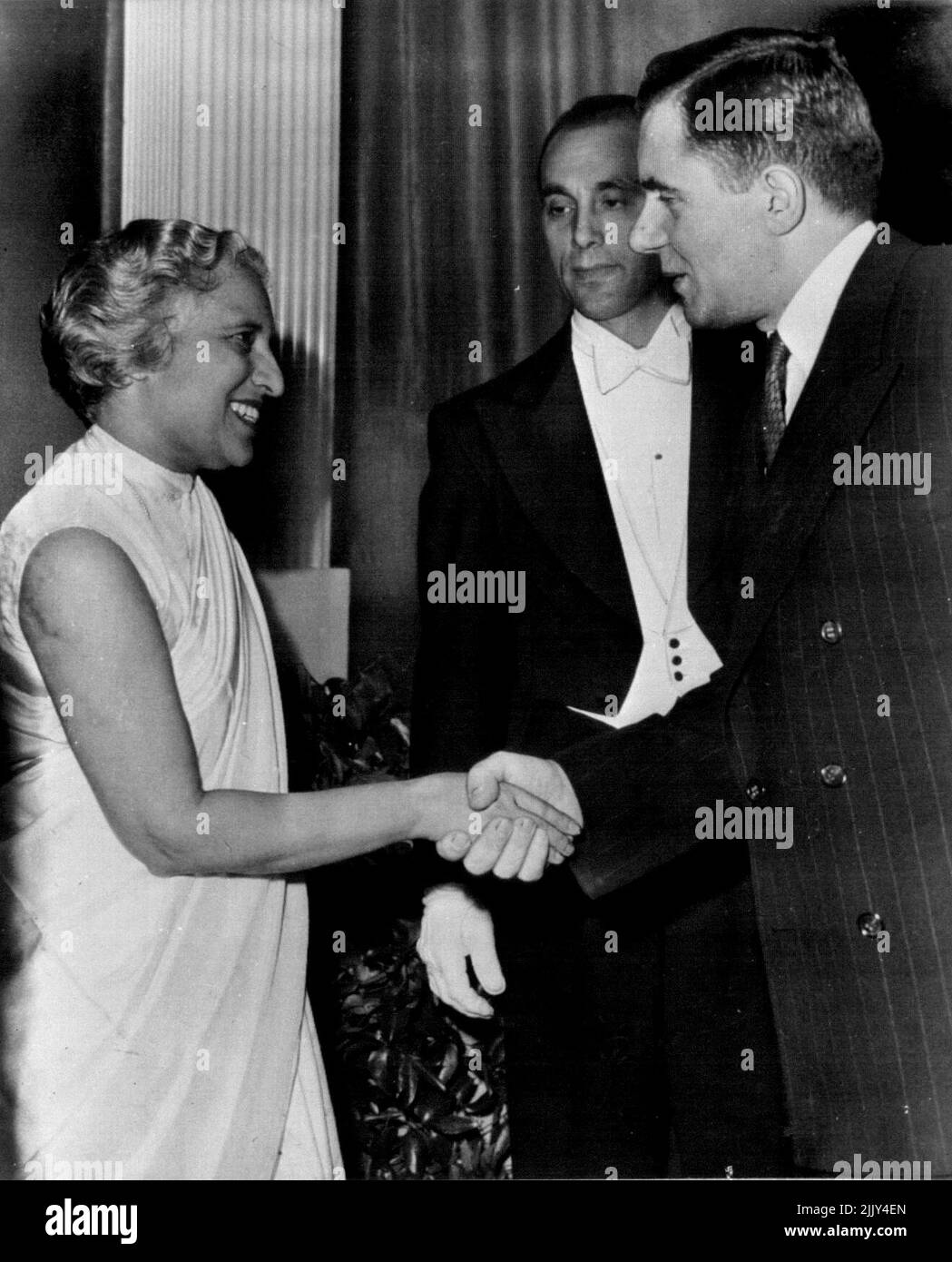 L'Inde accueille la Russie à Une réception à New York - Mme Vijaya Lakshmi Pandit (à gauche), Ambassadeur de l'Inde en Russie soviétique, Et président de la délégation indienne de l'Assemblée générale des Nations Unies, M. Andrei A. Gromyko, vice-ministre des Affaires étrangères de l'Union soviétique (à droite), souhaite la bienvenue à une réception qu'elle a donnée aux délégués des États-Unis ici, hier soir, à l'hôtel Waldorf-Astoria. L'homme dans le centre est un employé d'hôtel non identifié. 3 octobre 1947. (Photo par AP Wirephoto). Banque D'Images