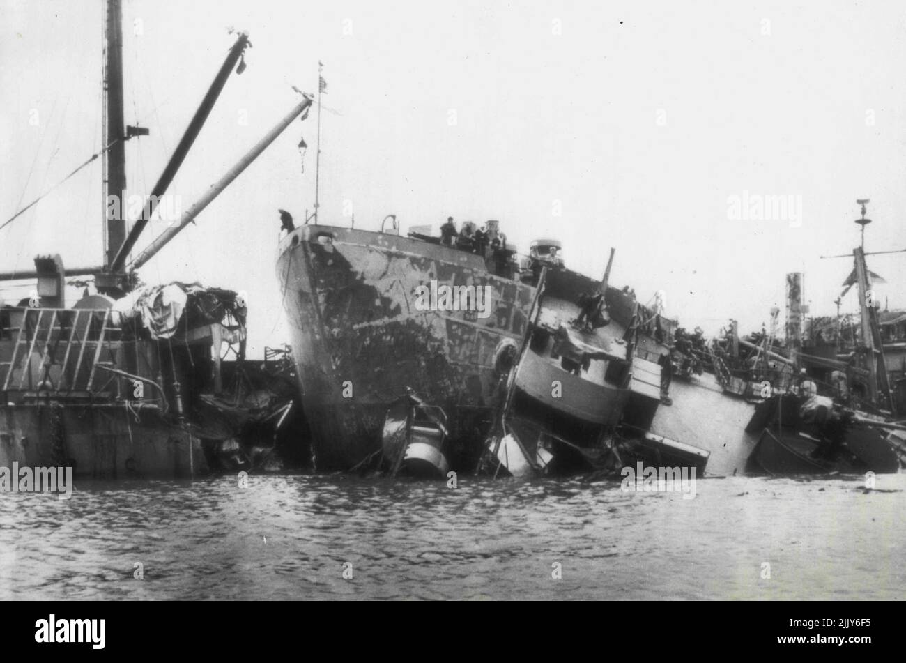 Des navires entrent en collision pendant le typhon d'Okinawa : l'épave du S.S. Ocelot est inondée dans la baie Buckner, à Okinawa, avec l'arc d'un ARB (navire de réparation, dégâts de bataille) qui se renverse dans les débris après que les navires aient été conduits ensemble par le typhon qui a balayé l'île le 9 octobre. Quelque 130 navires de la Marine ont été conduits en aggrégant par le vent de 140 mille par heure et les vagues de 20 pieds. 15 octobre 1945. (Photo par AP Wirephoto). Banque D'Images