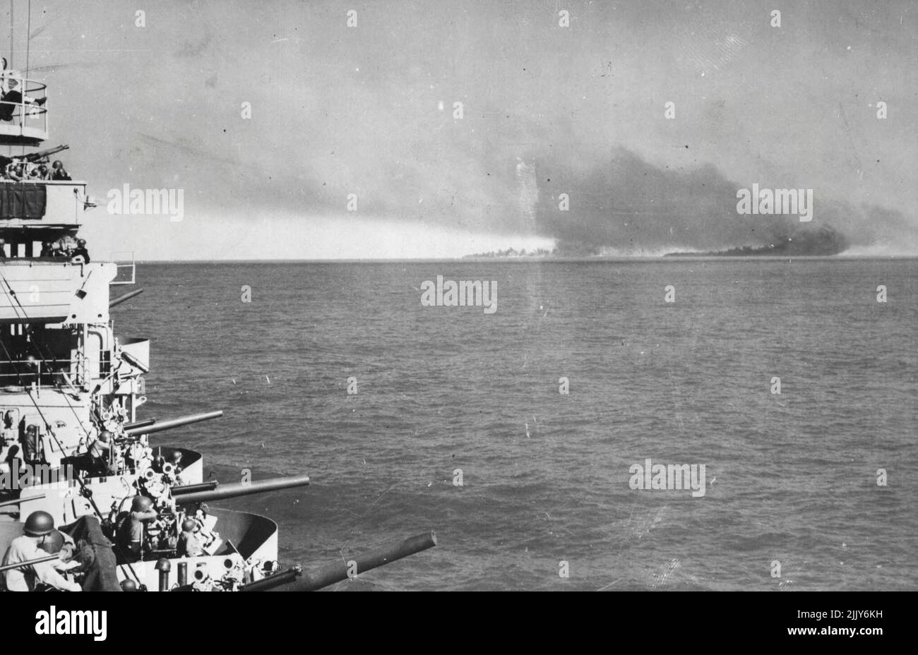 Les forces navales américaines de l'aide alliés des lantages en Sicile -- la fumée s'élève des installations de l'axe en feu sur la rive à Livata, en Sicile, à la suite d'un bombardement par le croiseur américain (à gauche) d'où cette photo a été prise, et d'autres navires de guerre alliés, à mesure que les débarquements initiaux d'invasion ont commencé. Plus de 1 500 navires de la Marine américaine, de la taille des croiseurs aux petits embargos et habités par 40 000 officiers et hommes, ont été parmi les 3 000 navires alliés qui ont participé aux gigantesques opérations amphibies. 29 août 1943. Banque D'Images