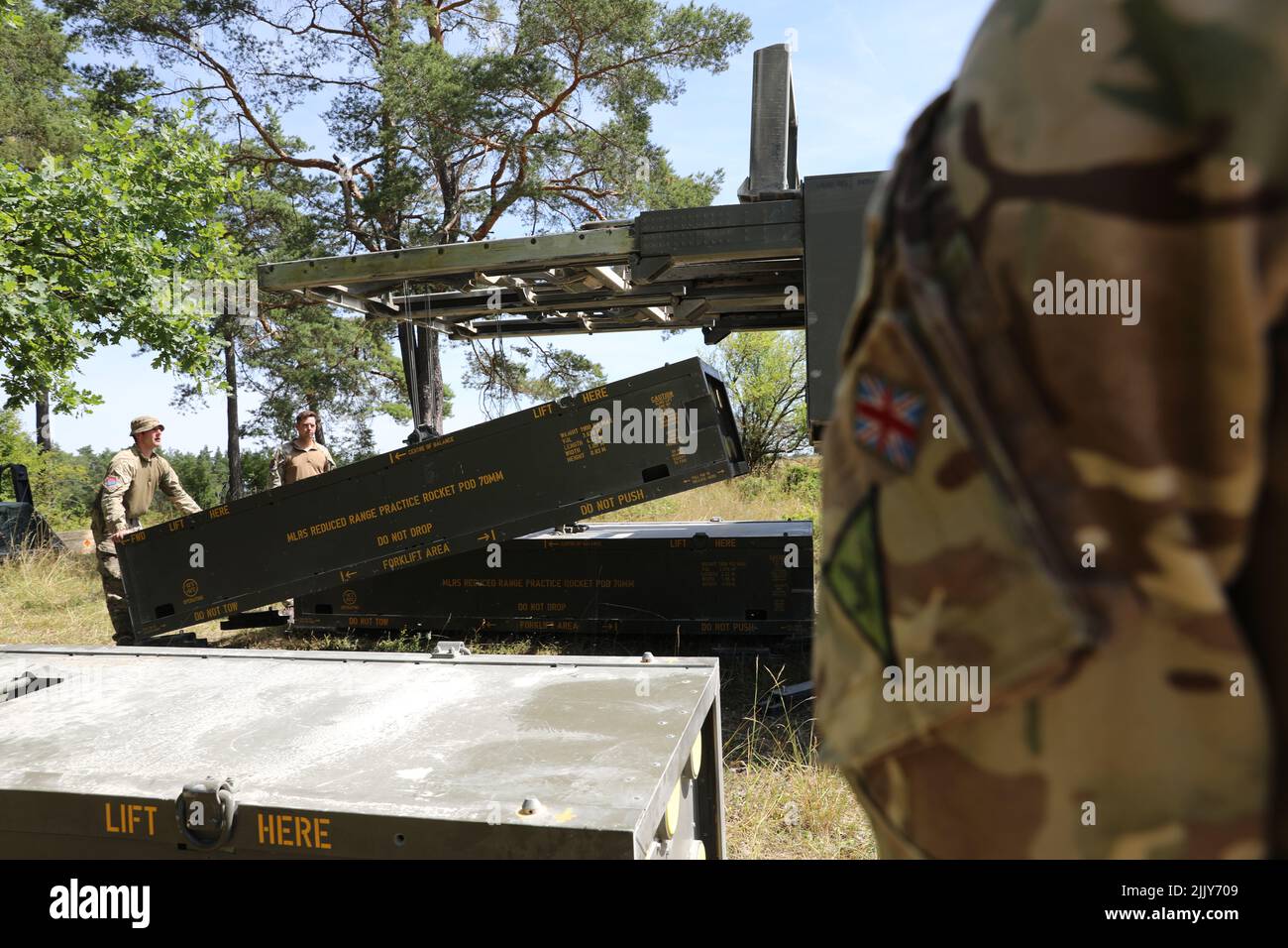 Les soldats britanniques affectés au Régiment Royal Artillery de 26th chargent des tours d'entraînement dans leur système de lancement multiple (MLRS) de M270 dans la zone d'entraînement de Grafenwoehr, Allemagne, 18 juillet 2022. Dynamic Front 2022, dirigé par le Commandement de l'Artillerie 56th et l'Armée américaine dirigée par l'Europe et l'Afrique, est le premier exercice de feux intégrés des alliés et partenaires de l'OTAN dirigé par les États-Unis dans le théâtre européen, axé sur l'interopérabilité des feux et l'augmentation de la préparation, de la létalité et de l'interopérabilité dans les domaines humains, procéduraux et techniques Photo de l'armée par le Maj. Joe Bush) Banque D'Images