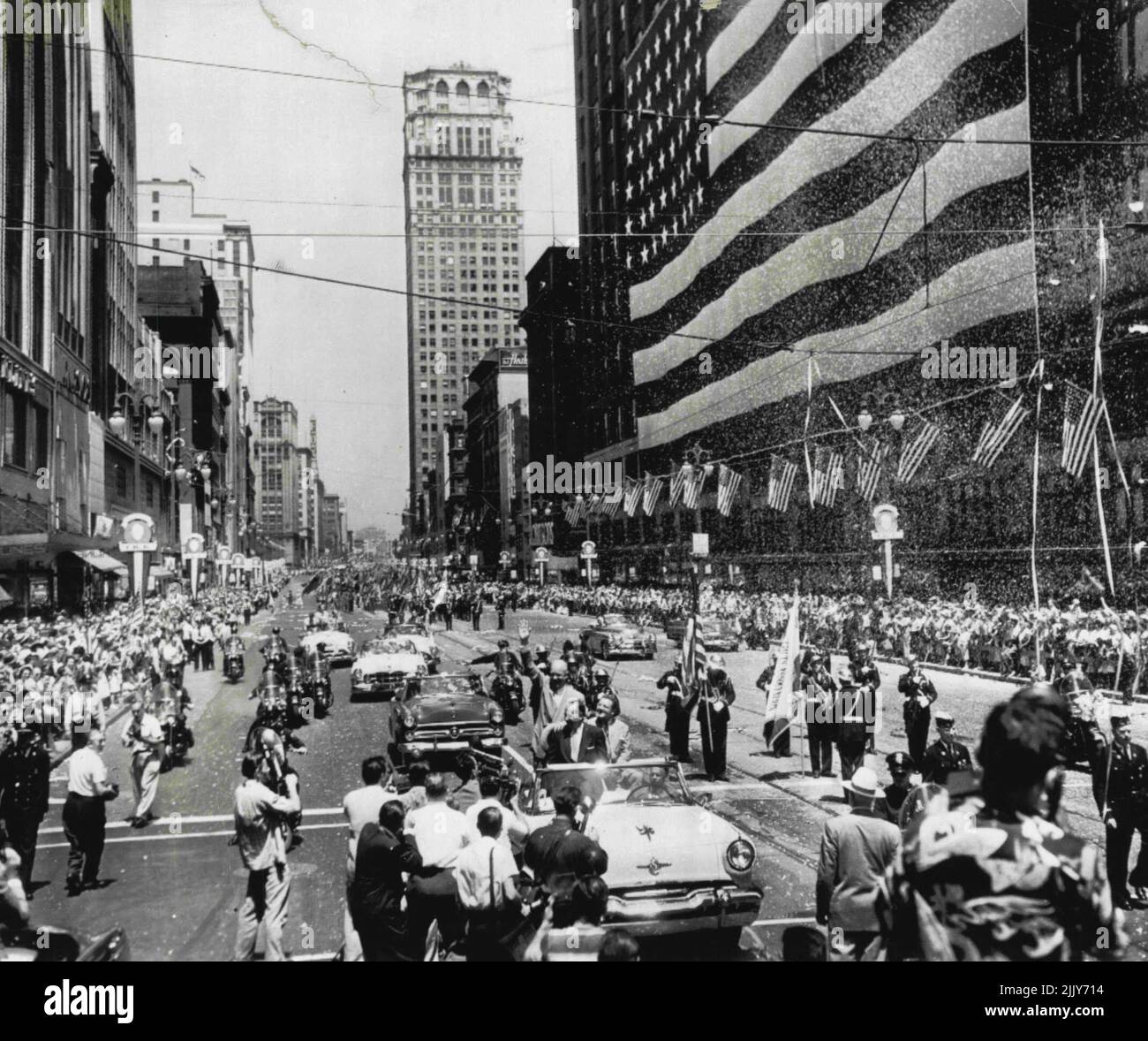 Drapeau Day Parade pour Ike -- Une voiture portant le général Dwight D. Eisenhower (au centre) fait son chemin lentement sur Woodward Ave., ici aujourd'hui sur le chemin de l'hôtel de ville où le général a fait un bref discours non politique. Des milliers de lignes de la ligne de mars pour voir Eisenhower tandis que d'autres lancèrent des confettis et du papier de fenêtres. À l'hôtel de ville, 40 000 personnes se sont debout sous un soleil brûlant et ont répété la promesse d'allégeance avec lui à la fin de son discours du jour du drapeau. 14 juin 1952. (Photo par AP Wirephoto). Banque D'Images